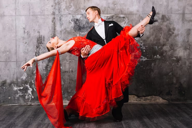 Professional ballroom dance instructor performing a dramatic dance pose with a partner, representing how to build a career as a ballroom dance instructor.